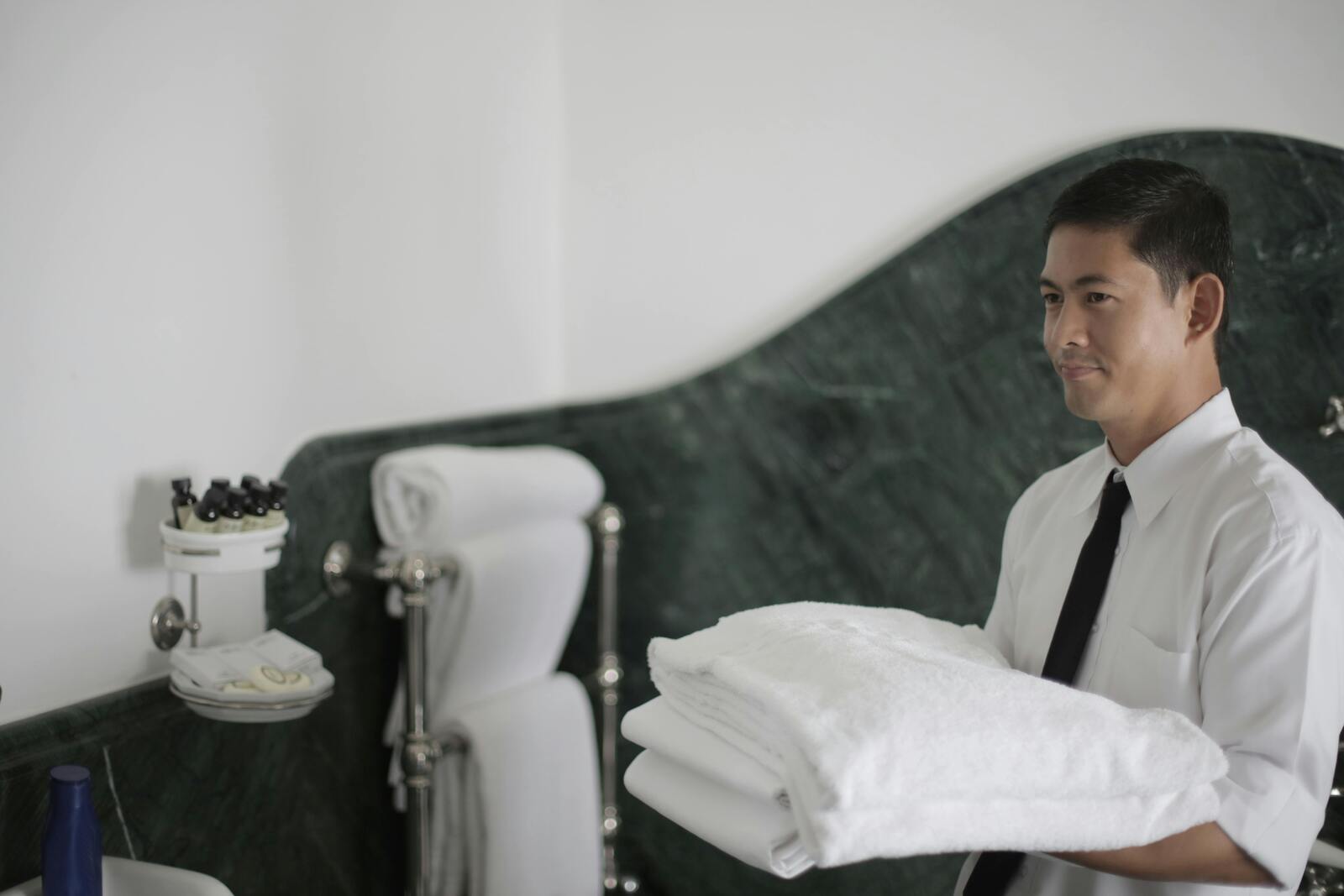 A man carrying a white bed linen cloth